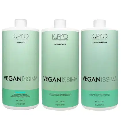 Três frascos de produtos de cabelo da linha Veganíssima da marca K.Pro, incluindo shampoo, acidificante e condicionador, com embalagens de plástico verde-claro e rótulos em preto e branco.
