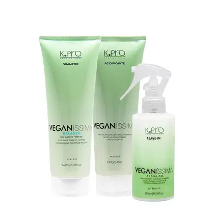 Três produtos da linha Veganissima da marca K.Pro: shampoo, acidificante e leave-in, em embalagens plásticas de cores verde e branca, com rótulos indicando os nomes e características dos produtos.