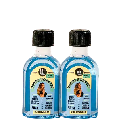 Dois pequenos frascos de vidro azul transparente contendo um líquido oleoso para cabelos. Os frascos têm tampas pretas texturizadas e rótulos amarelos com o logotipo "Lola From Rio" e a inscrição "Danos Vorazes" em letras verdes.