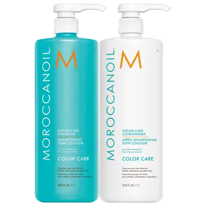 A imagem mostra o Shampoo e Condicionador Moroccanoil Color Care 1L. Dois frascos plásticos com bombas dosadoras brancas. O shampoo é um frasco azul turquesa com o logotipo laranja "M". O condicionador é um frasco branco com o mesmo logotipo laranja "M".