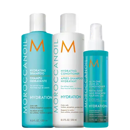 A imagem mostra três produtos da marca Moroccanoil. São um shampoo hidratante, um condicionador hidratante e um leave-in condicionador "All in One", todos em embalagens plásticas cilíndricas. Cores predominantes são turquesa, branco e laranja.