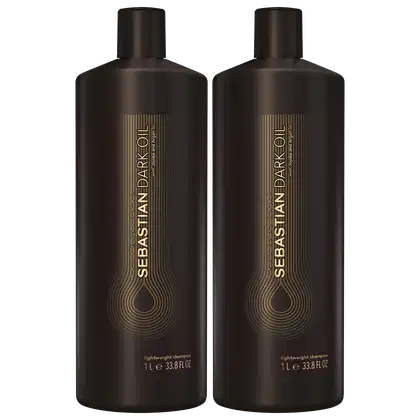 São dois frascos de shampoo leve da marca Sebastian Professional. Os frascos são de plástico marrom escuro e têm formato cilíndrico com tampa preta. Na parte frontal, há o logotipo e nome da marca "Sebastian Dark Oil" em letras douradas.