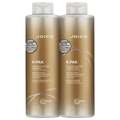 São dois frascos de plástico dourado de 1 litro cada, contendo shampoo e condicionador reconstrutores da linha K-Pak da marca Joico. Os frascos têm formato cilíndrico e tampas brancas.