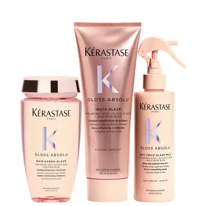 Três produtos da marca Kérastase: um frasco de shampoo Bain Hydra-Glaze, um tubo de condicionador Gloss Absolu e um frasco de spray Gloss Absolu, todos em embalagens com cores rosa e branca.