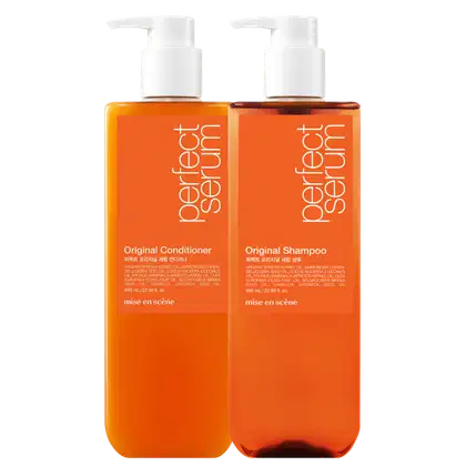 Dois frascos de plástico laranja com bombas brancas, contendo Shampoo Original e Condicionador Original da marca Mise en Scène. Os rótulos exibem informações sobre os ingredientes e a marca.