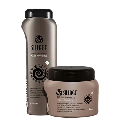 Dois produtos da marca Sillage: um frasco de shampoo premium Curl-Revealing de 300ml e um pote de hidratação intensiva Curl-Revealing de 300g, ambos com embalagens em tons de cinza e preto.