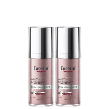 Dois frascos de serum facial Anti-Pigment da marca Eucerin, com embalagem prateada e rosa, apresentando o texto "Anti-Pigment Dual Sérum Facial" e o logotipo da marca.