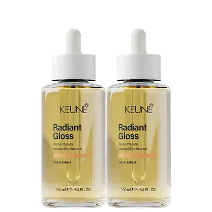 Dois frascos de vidro transparente contendo um líquido dourado, com rótulos brancos exibindo o nome da marca "Keune" e o nome do produto "Radiant Gloss". Cada frasco possui um conta-gotas branco no topo.