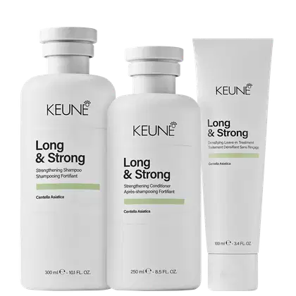 Produtos da linha Long & Strong da Keune, incluindo shampoo, condicionador e tratamento capilar, em embalagens brancas com detalhes em verde, destacando ingredientes como Centella Asiática.