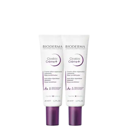 Dois tubos de creme Cicabio Creme+ da Bioderma, um creme ultra-reparador calmante para peles sensibilizadas, com embalagem branca e roxa, contendo 20 ml cada.