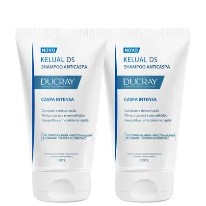 Dois frascos de shampoo anticaspa da marca Ducray, com rótulos em azul e branco indicando "Caspa Intensa" e "Kelual DS Shampoo Anticaspa". Cada frasco possui 100mL de produto.