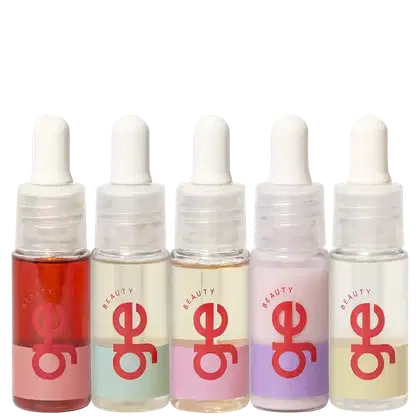 Cinco frascos com contagotas de GE Beauty em cores variadas: vermelho, bege, rosa claro, roxo e amarelo claro. Embalagens transparentes com rótulos vermelhos e tampas brancas arredondadas.