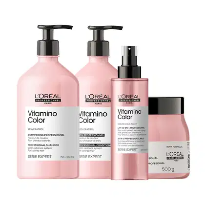 Conjunto de produtos L'Oréal Professionnel da linha Vitamino Color, incluindo shampoo, máscara, condicionador e sérum em embalagens rosa e preta com rótulos indicando os benefícios para cabelos coloridos.