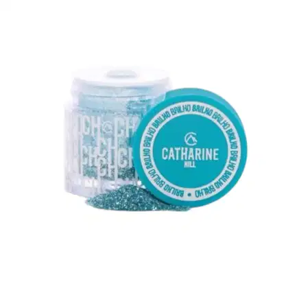 Frasco de produto de beleza da marca Catharine Hill, com tampa azul turquesa e rótulo destacando o nome da marca. O frasco contém um produto em pó de cor azul clara, provavelmente um produto de maquiagem ou cosmético.