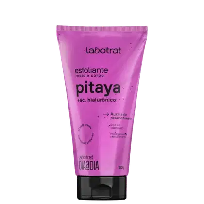 O produto exibido é um esfoliante corporal da marca Labotrat, com o nome "pitaya" e a indicação de conter ácido hialurônico. A embalagem é um tubo de plástico rígido de cor rosa vibrante, com o nome da marca e do produto claramente visíveis.