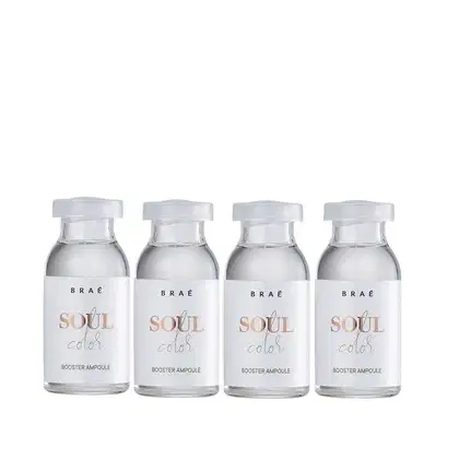 A imagem mostra quatro pequenas ampolas de vidro transparente contendo um líquido. As ampolas têm tampas brancas e estão rotuladas como "BRAE Soul Color Booster Ampoule".