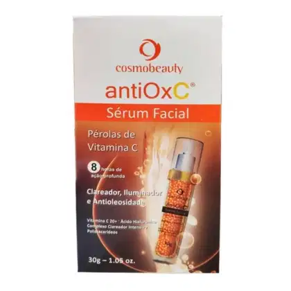 Caixa branca com logotipo Cosmobeauty e nome do produto "antiOxC Sérum Facial" em destaque. Contém informações sobre os ingredientes, como "Pérolas de Vitamina C" e "Ácido Hialurônico". Embalagem com 30g