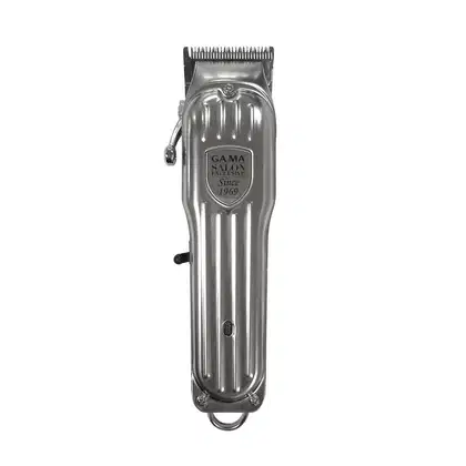 Máquina de cortar cabelo da marca GA.MA Italy, fabricada desde 1969. Corpo metálico cromado com linhas retas e detalhes arredondados. Possui uma lâmina larga com dentes finos e um pente guia ajustável.