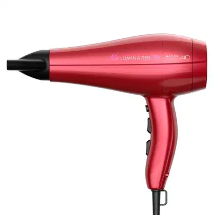 A imagem mostra um secador de cabelo vermelho da marca GA.MA Italy. O produto tem um design alongado e aerodinâmico, com um corpo vermelho brilhante e detalhes pretos. O secador apresenta um visual moderno e elegante.