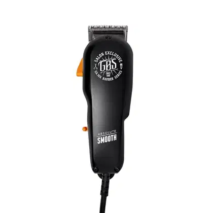 A imagem mostra uma máquina de corte preta com detalhes laranja. O corpo é cilíndrico com o logotipo "GBS Salon Exclusive" e a frase "Absolute Smooth" gravada. Possui uma lâmina de corte aparente na parte superior. O design é simples e moderno.