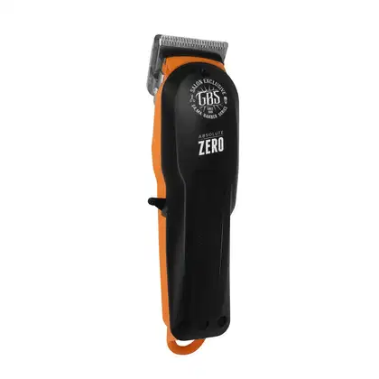 A imagem mostra uma máquina de cortar cabelo com corpo preto com detalhes em laranja. Possui uma lâmina aparadora visível e o logotipo "GBS Salon Exclusive" impresso na parte superior.