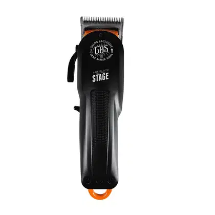 A imagem mostra uma máquina de corte preta com detalhes laranja. O corpo é cilíndrico com o logotipo "GBS Salon Exclusive" e a frase "Absolute Stage" gravada. Possui uma lâmina de corte aparente na parte superior. O design é simples e moderno.