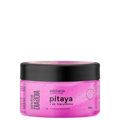 O produto apresentado é um esfoliante corporal da marca Labotrat, com o nome "pitaya + ác. hialurônico" impresso no rótulo. A embalagem é um pote preto com tampa, contendo um produto de cor rosa vibrante.
