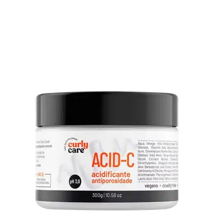 É um produto de tratamento capilar da linha Curly Care. A embalagem é um pote plástico branco com tampa preta. O rótulo indica que é o produto "Acid-C", um acidificante antiporosidade com pH 3.0.