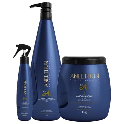 A imagem mostra 3 produtos da linha A de Aneethun, sendo um spray de tratamento em um frasco menor, um shampoo de 1L em um frasco grande e um pote redondo de máscara capilar. Todos possuem a cor azul escura e detalhes em dourado.