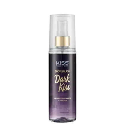 A imagem mostra o Body Splash em uma embalagem com cores roxo, branco e dourado, apresentando o logotipo Kiss New York. A tampa é transparente e traz um detalhe dourado na válvula spray.