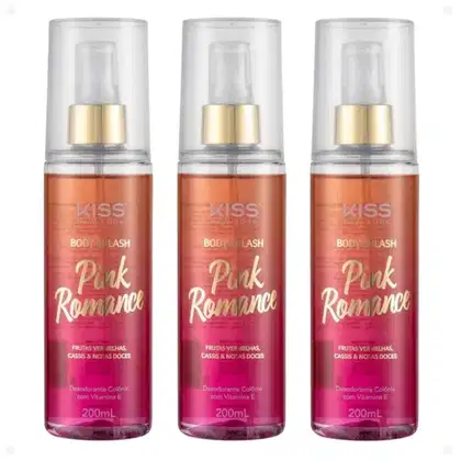 Três frascos de Body Splash Pink Romance de 200ml cada. Os frascos são transparentes com detalhes em rosa e dourado. O líquido dentro tem uma cor rosa avermelhada. O rótulo indica que tem fragrância de frutas vermelhas, cassis e notas doces.