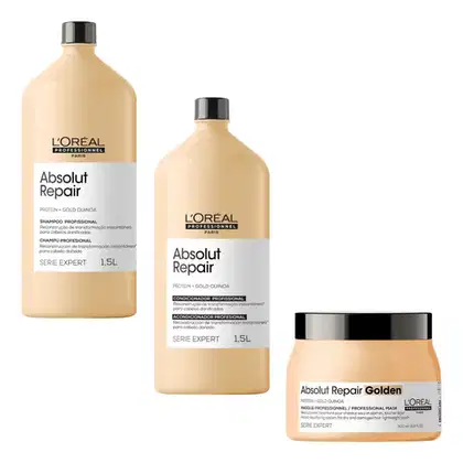 A imagem mostra três produtos da linha Absolut Repair da L'Oréal Professionnel. Dois frascos de 1,5 litros de shampoo e condicionador com proteína e quinoa dourada. Um terceiro produto é uma máscara profissional em um pote plástico bege com tampa preta.