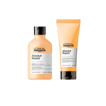 A imagem mostra dois produtos de cuidados capilares da linha Absolut Repair da L'Oréal Professionnel. Um é um shampoo em um frasco laranja, com tampa preta. O outro é um condicionador em um tubo plástico laranja, também com detalhes pretos.