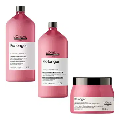 A imagem mostra 3 produtos da linha Pro Longer da L'Oréal Professionnel. Um shampoo em uma embalagem plástica rosa de 1,5L. Outro é um condicionador em uma embalagem semelhante de 1,5L. O terceiro é uma máscara capilar em um pote rosa de 250g.