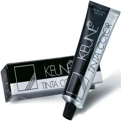 Tinta de cabelo da marca Keune. A embalagem consiste em uma caixa preta com detalhes em branco e cinza, exibindo o nome da marca "Keune" e a descrição "Tinta Color".
