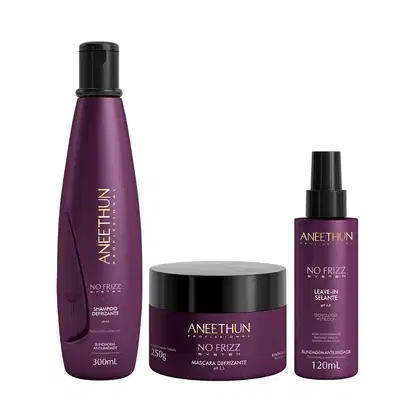 Shampoo defrizante em frasco plástico roxo de 300ml. Máscara defrizante em pote plástico preto de 250g. Leave-in selante defrizante em frasco plástico spray roxo de 120ml. Cores predominantes são roxo e preto.