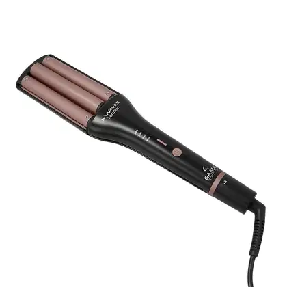 Este é um modelador de cabelo cerâmico da marca GA.MA Italy. O produto tem um design alongado e cilíndrico, com uma carcaça preta e três cilindros cerâmicos revestidos em uma cor marrom rosada. Na parte superior, há um visor digital e botões de controle.