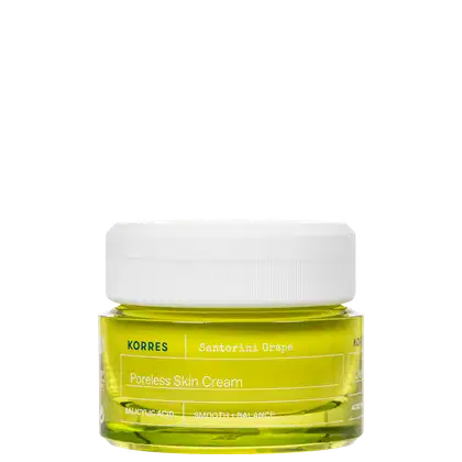 Frasco de creme facial da marca Korres, com rótulo amarelo e branco indicando "Poreless Skin Cream" e "Santorini Grape". O produto contém um líquido de coloração amarelo-esverdeada.