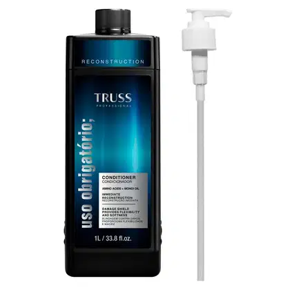 A imagem mostra um frasco de condicionador com uma tonalidade preta e rótulo com fundo azul escura. Traz informações na cor cinza e preta. O tamanho do frasco é de 1l e ao lado, tem uma válvula pump.