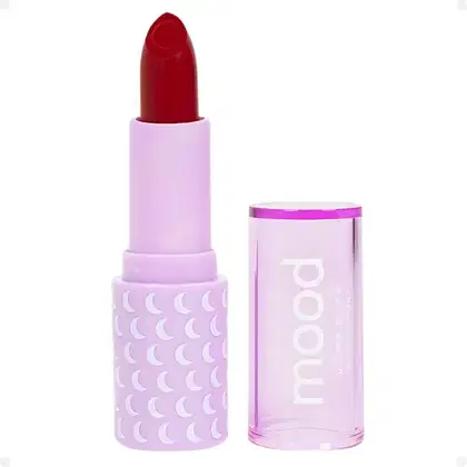 Batom da marca Ruby Rose. O batom possui uma embalagem de plástico lilás com um design de luas brancas. O próprio batom é de cor vermelha intensa. A embalagem também exibe o nome da marca "Ruby Rose" em letras brancas.