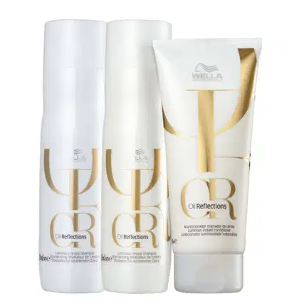 Dois shampoos e um condicionador, embalagens brancas com detalhes dourados.