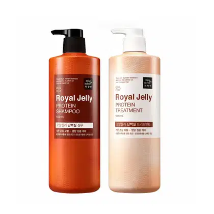 Dois itens da linha Royal Jelly da marca Mise en Scène. O primeiro é um shampoo de proteína de geleia real, com um dispensador preto. O segundo é um tratamento de proteína de geleia real, em uma embalagem bege com um dispensador branco.