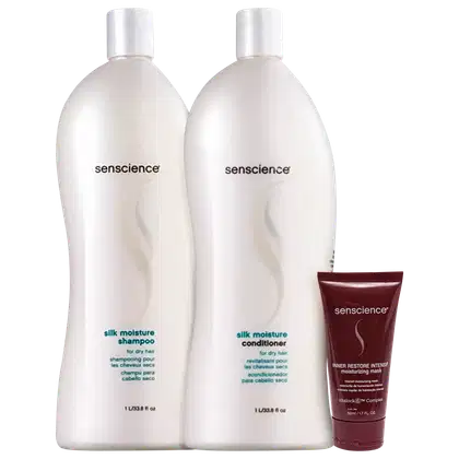 A imagem mostra dois grandes frascos de plástico branco opaco com tampas brancas, contendo shampoo e condicionador. Ao lado, um tubo vinho com a embalagem de uma máscara hidratante da mesma marca.