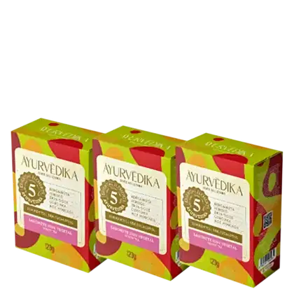 três caixas de sabonete sólido da marca Ayurvedika. O texto indica que se trata de um sabonete vegetal com ingredientes ayurvédicos, como bergamota, hibisco e lótus. Cada caixa contém 120g do produto.