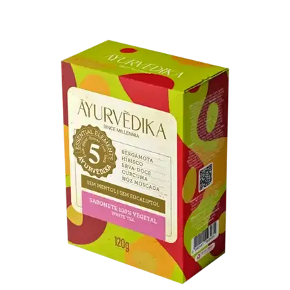 Sabonete 100% vegetal da marca Ayurvedika. A embalagem é uma caixa retangular de cor verde e rosa, com informações sobre os ingredientes do produto, como bergamota, hibisco, erva-doce, cúrcuma e noz-moscada.