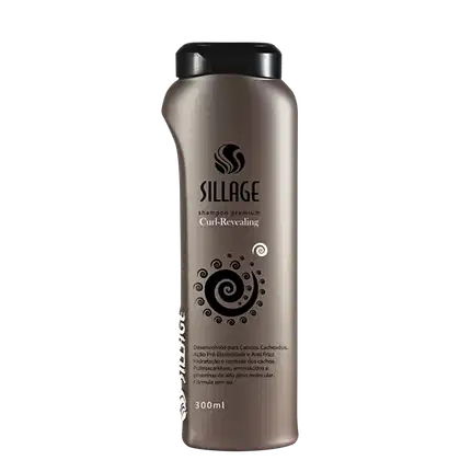Frasco de shampoo premium da marca Sillage, com design moderno e elegante em tons de cinza. O rótulo destaca o nome da linha "Curl-Revealing" e apresenta detalhes gráficos em espiral, indicando seu propósito de realçar os cachos.