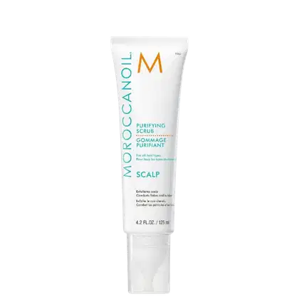 Tubo branco com rótulo laranja e azul da marca Moroccanoil, contendo um esfoliante purificante para o couro cabeludo. O produto é indicado para todos os tipos de cabelo e promete combater caspas e construir volume.