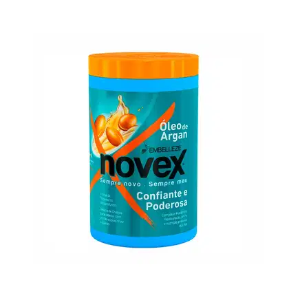 A imagem mostra o Creme de Tratamento Óleo de Argan 400g da marca Novex. É um pote plástico cilíndrico na cor azul com tampa laranja. O rótulo destaca que o produto oferece restauração, brilho e nutrição profunda.