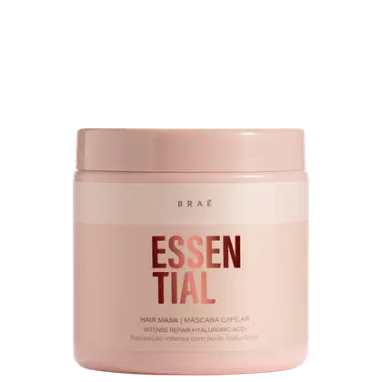 Máscara capilar Essential da marca Braé. Embalagem plástica rígida na cor rosa claro. Rótulo na parte frontal com o nome do produto "Essential" em letras vermelhas grandes.