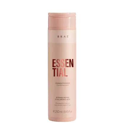 Condicionador Essential da marca Brae. Embalagem cilíndrica de plástico rígido na cor rosa claro. Rótulo com o nome do produto "Essential" em letras grandes vermelhas e a palavra "Conditioner" abaixo em letras menores.